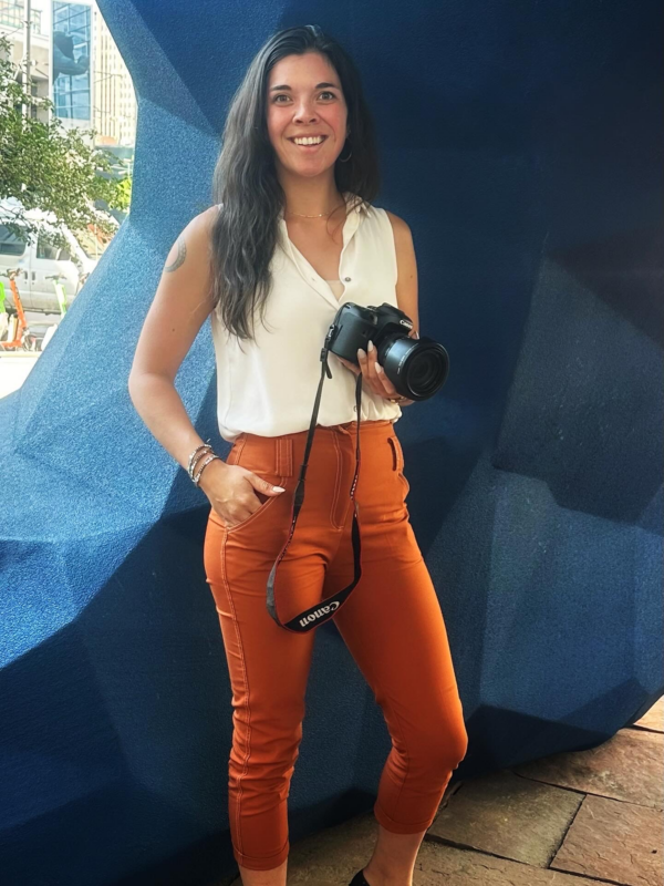 Kim Lavoie, Events Coordinator for the Combat Recovery Foundation, holding a Canon camera outdoors